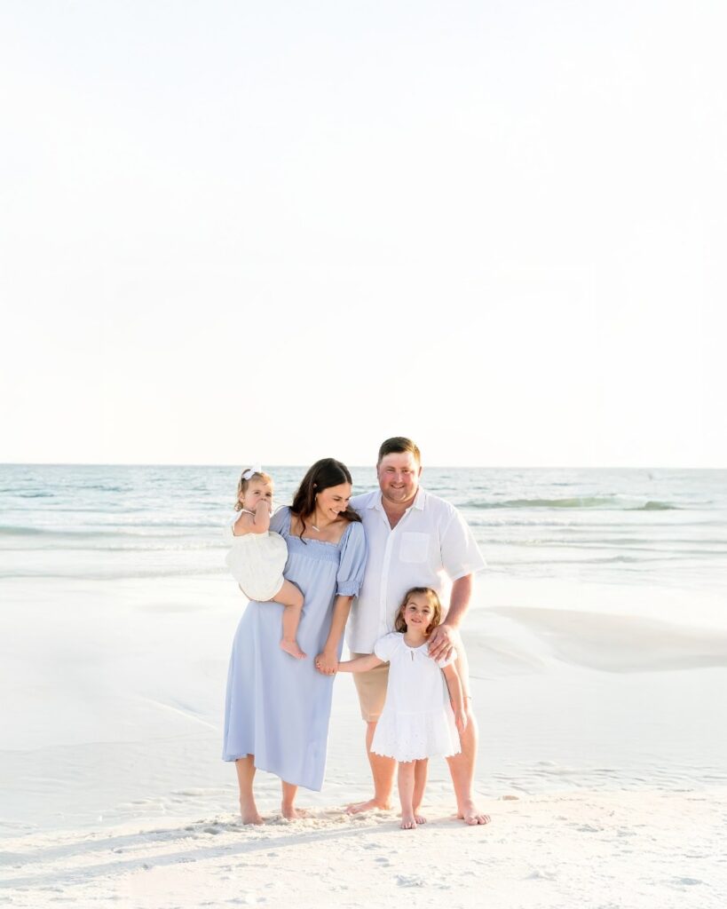 Family of four standing together on the beach during a 30A extended family photography session.