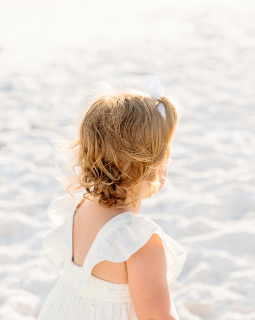 Young girl looking out across the beach during a 30A extended family photography session.