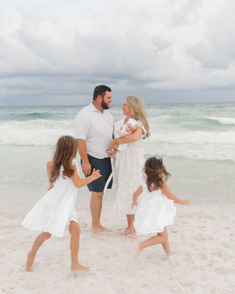 Parents welcoming a new baby during a Destin Florida beach family session
