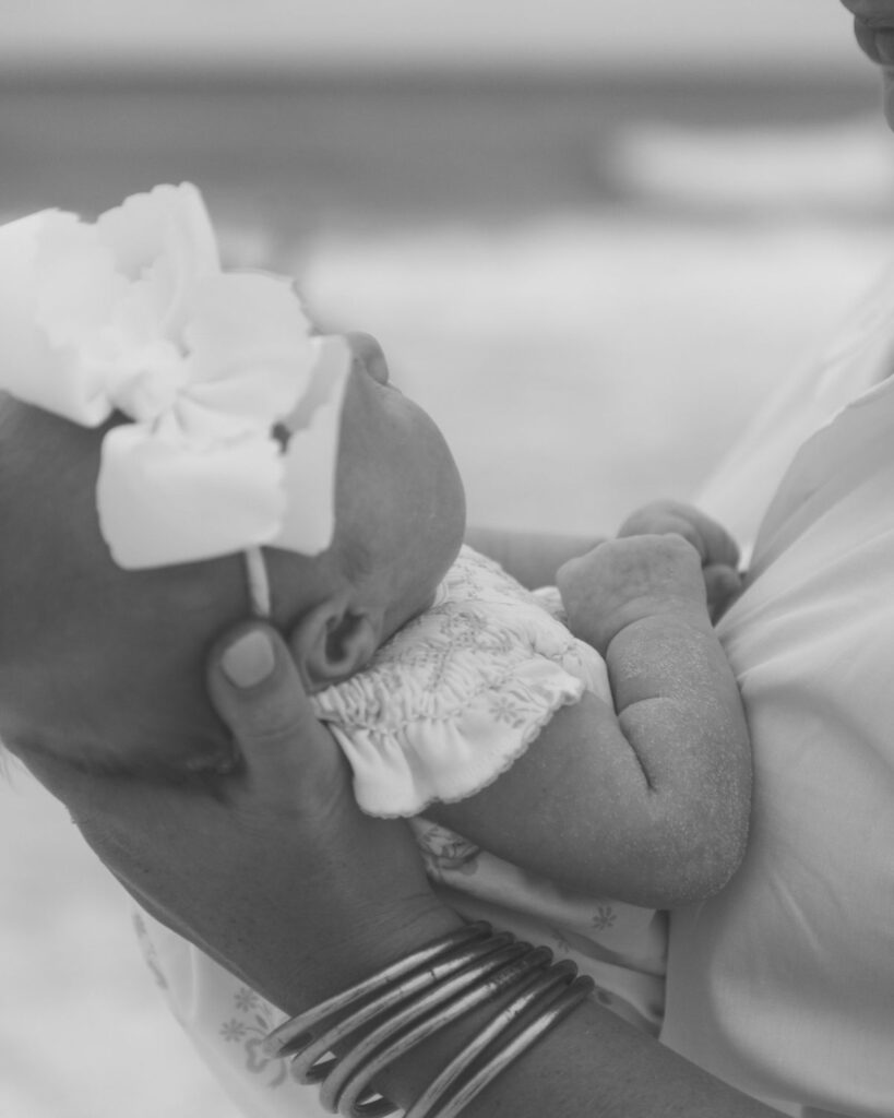 Mother and newborn baby girl photographed at The Henderson Resort beach in Destin