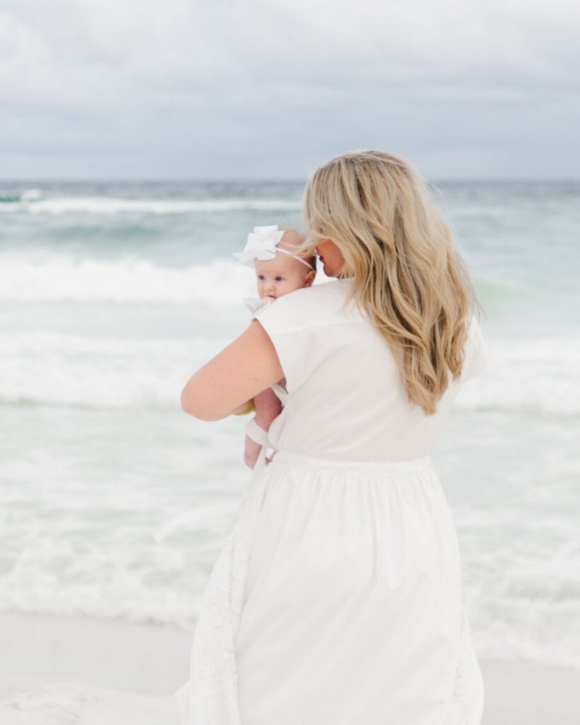 Mother and newborn baby girl photographed at The Henderson Resort beach in Destin