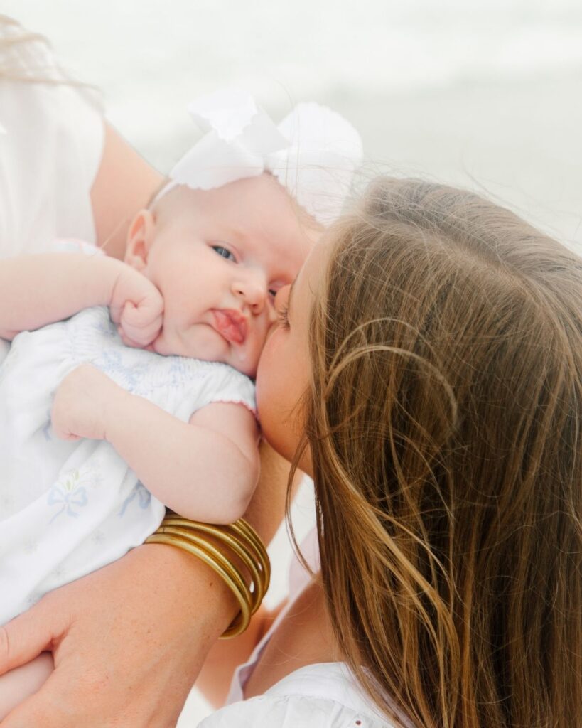 Family of five gathered together on the shoreline at The Henderson in Destin