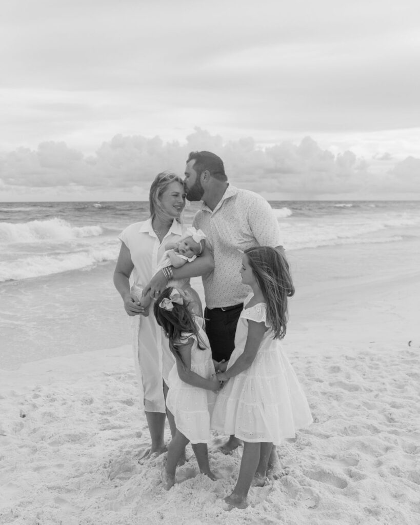 Family of five gathered together on the shoreline at The Henderson in Destin