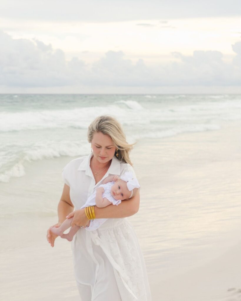 Mother holding her newborn baby girl during a beach family session in Destin Florida