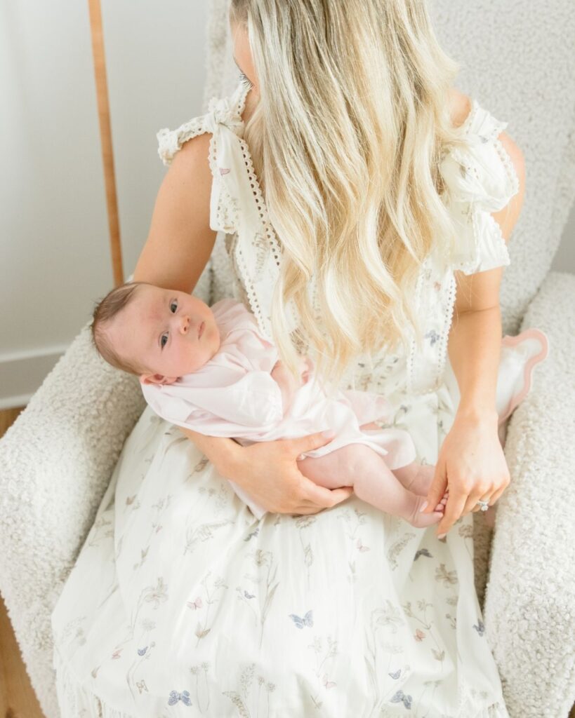 Mother holding newborn during an in-home lifestyle newborn session in Santa Rosa Beach Florida