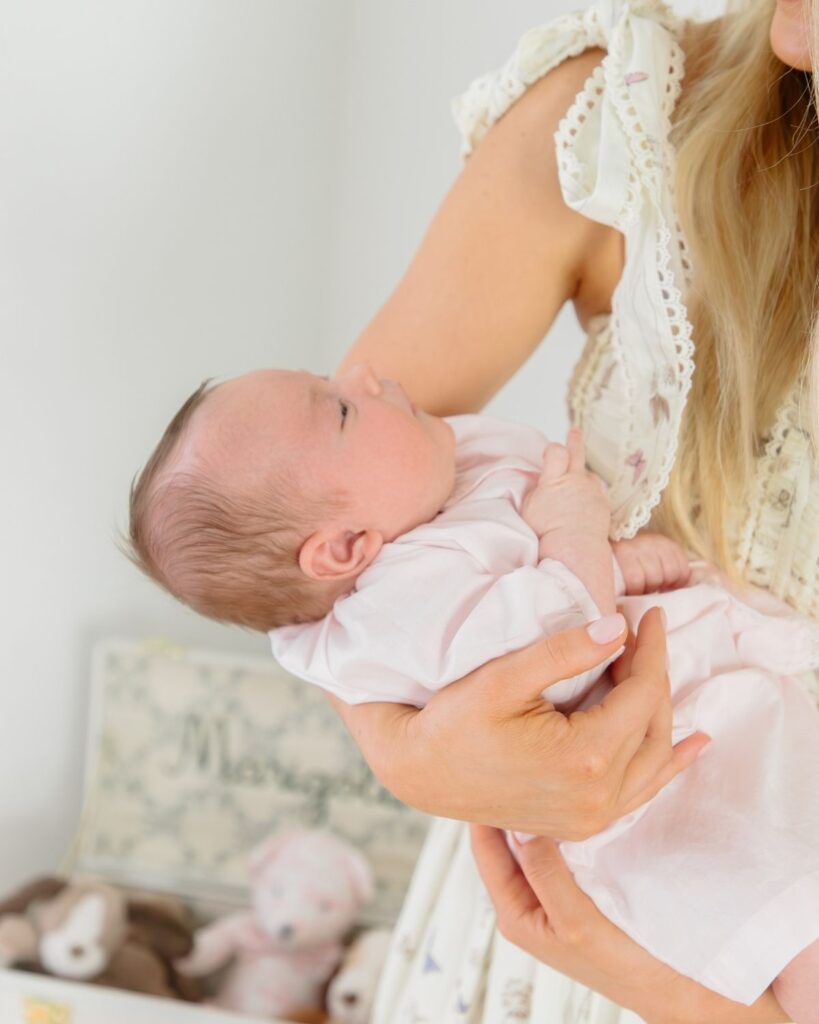 Mother holding newborn during an in-home lifestyle newborn session in Santa Rosa Beach Florida