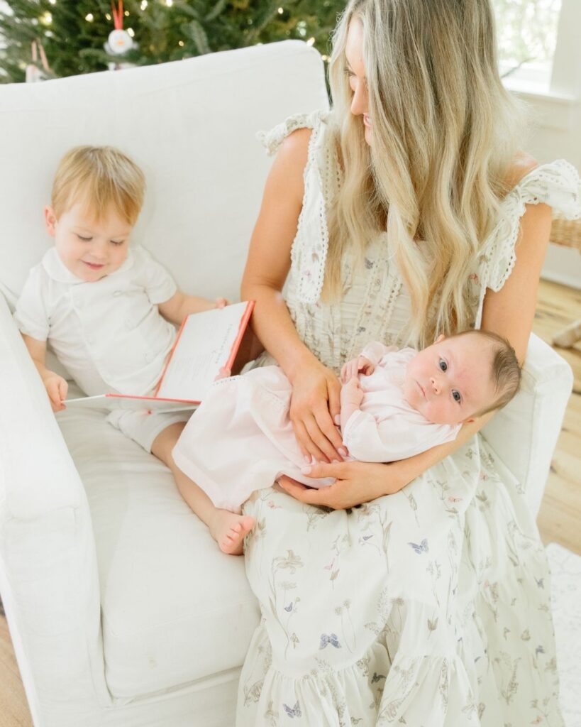 Toddler sibling holding newborn during an in-home lifestyle newborn session in Santa Rosa Beach Florida