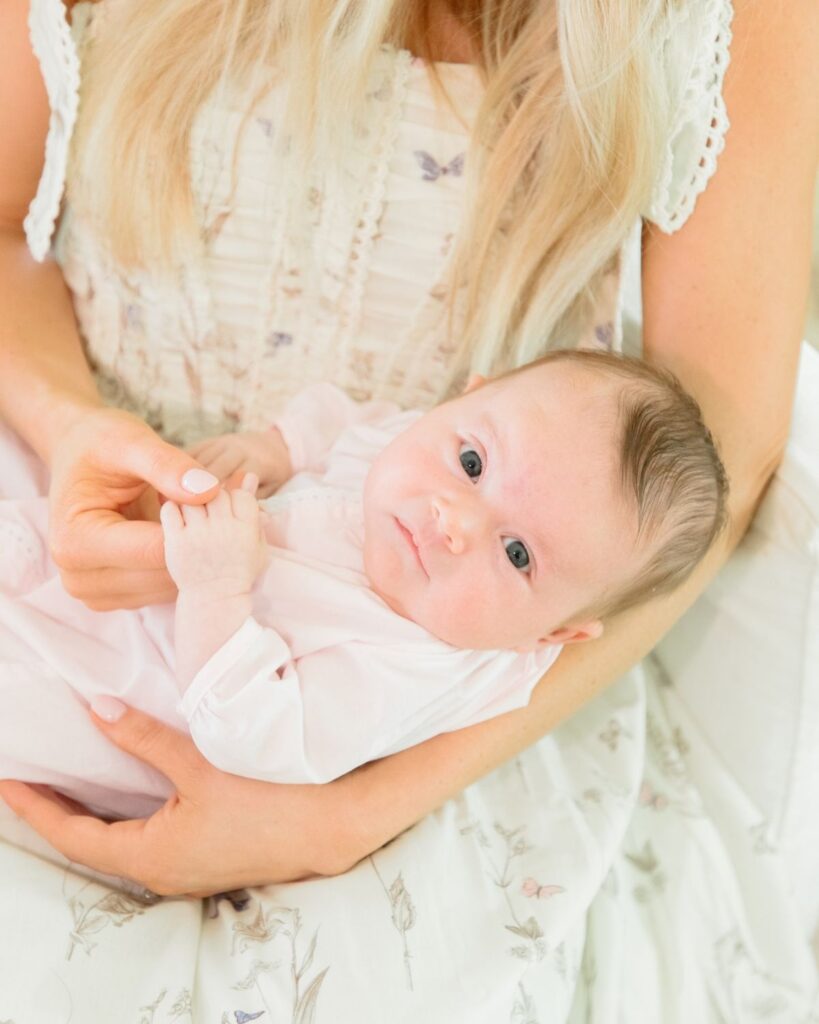 Mother holding newborn during an in-home lifestyle newborn session in Santa Rosa Beach Florida