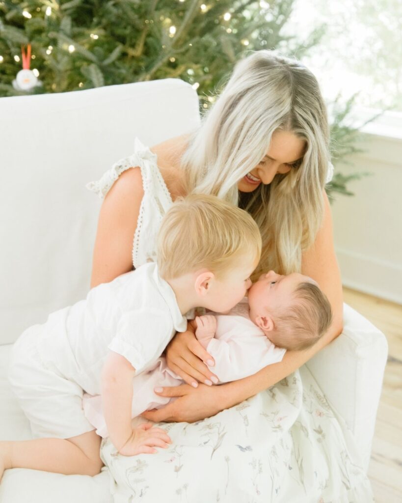 Toddler sibling holding newborn during an in-home lifestyle newborn session in Santa Rosa Beach Florida