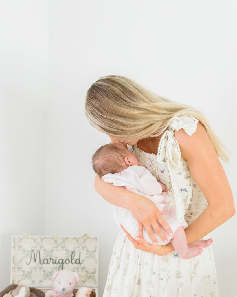 Mother holding newborn during an in-home lifestyle newborn session in Santa Rosa Beach Florida