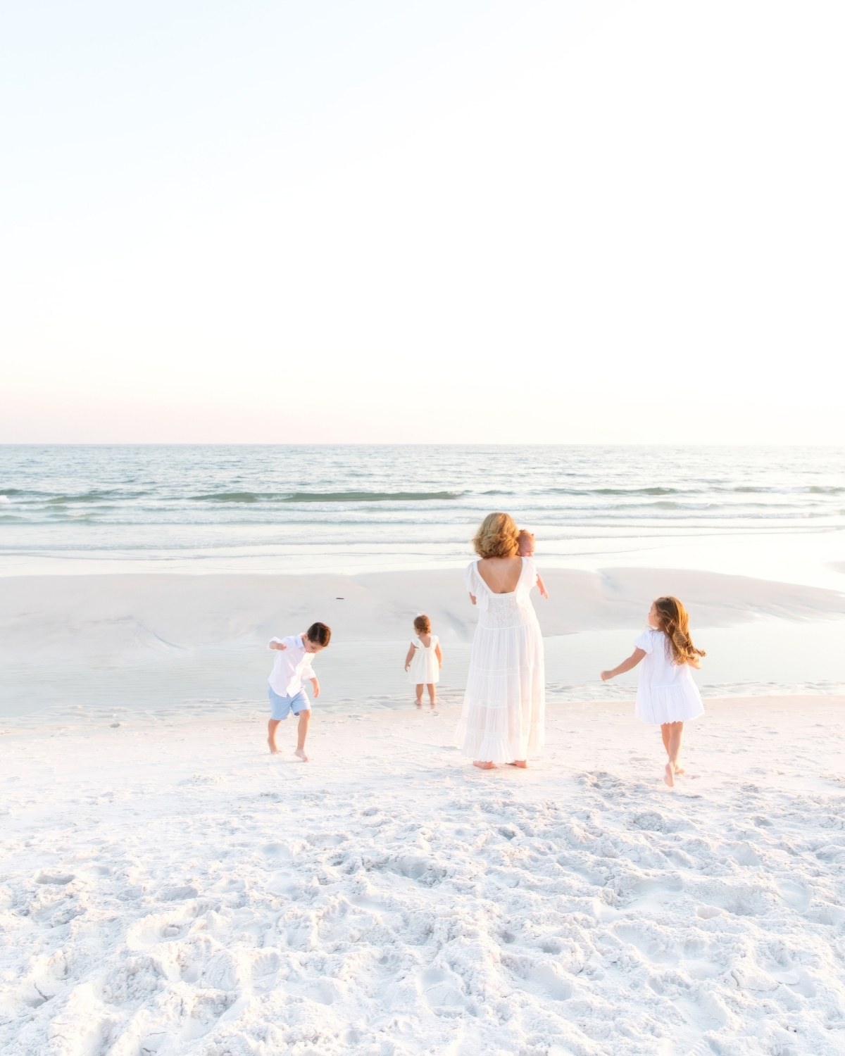 Grandmother walking on the beach with her grandchildren during a 30A extended family photography session.